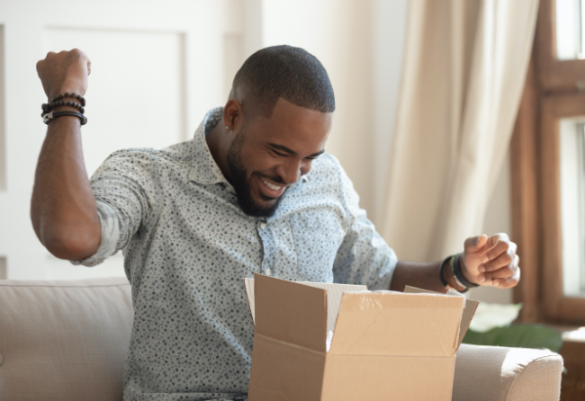 Black African American man opening a box and looking excited