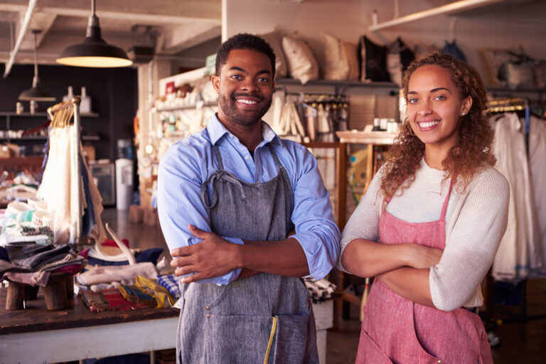 African American Black man and woman business owners in a workshop wearing aprons